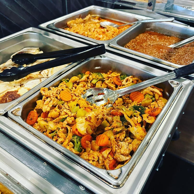 Mi Casita's buffet with trays of Mexican food including chicken and vegetables, shredded chicken, and beans.