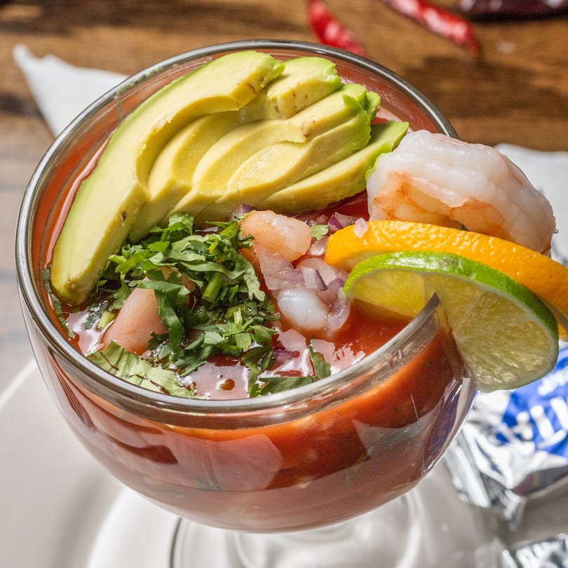 Mi Casita's shrimp cocktail with avocado, cilantro, and citrus slices in a glass.