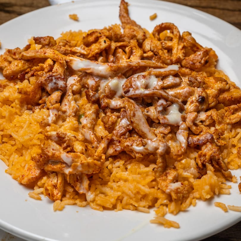 Mi Casita's Mexican rice topped with seasoned chicken strips and a creamy white sauce.